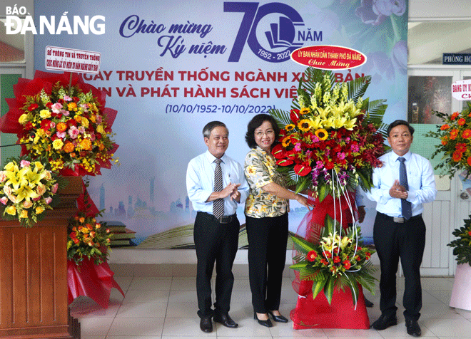 Phó Chủ tịch UBND thành phố Ngô Thị Kim Yến (giữa) tặng hoa chúc mừng Nhà xuất bản Đà Nẵng. Ảnh: XUÂN DŨNG	